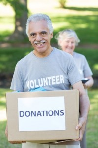 Happy volunteer senior holding donation box